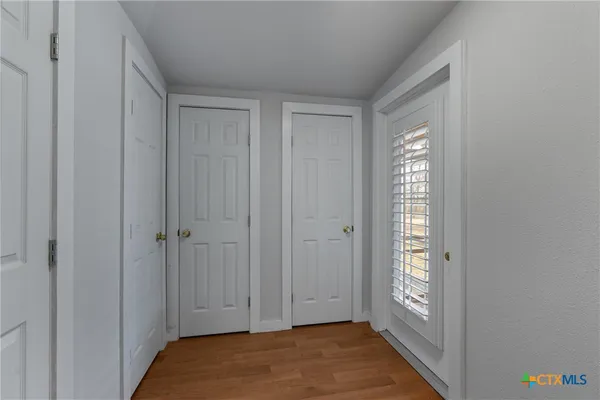 a view of an empty room with bathroom and a window