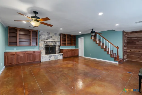a view of a livingroom with a ceiling fan and kitchen space
