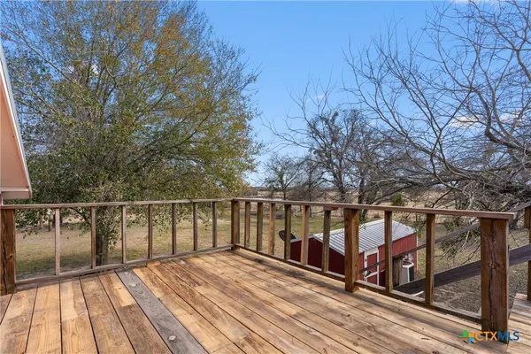 a view of balcony with wooden floor and fence