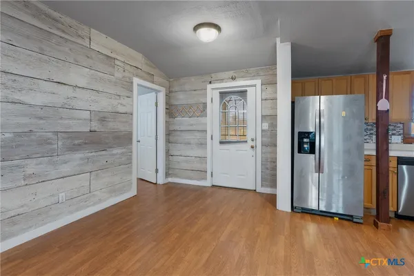 a view of an empty room with wooden floor