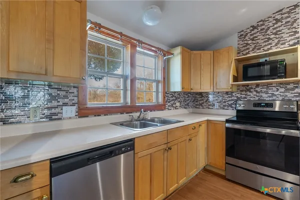 a kitchen with a sink stove and microwave
