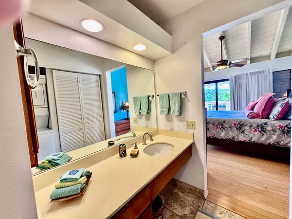 a bedroom with a bed a table and dresser