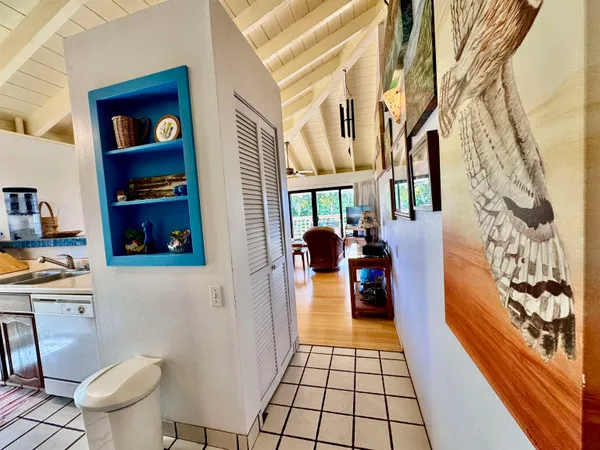 a hallway with a black white checkered floor and a dining table chair