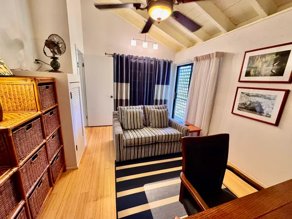 a hallway with a couch and a bookshelf with wooden floor