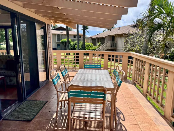 a view of a balcony with dining area and glass door