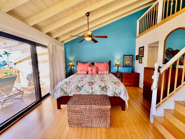 a bedroom with a bed a window and wooden floor