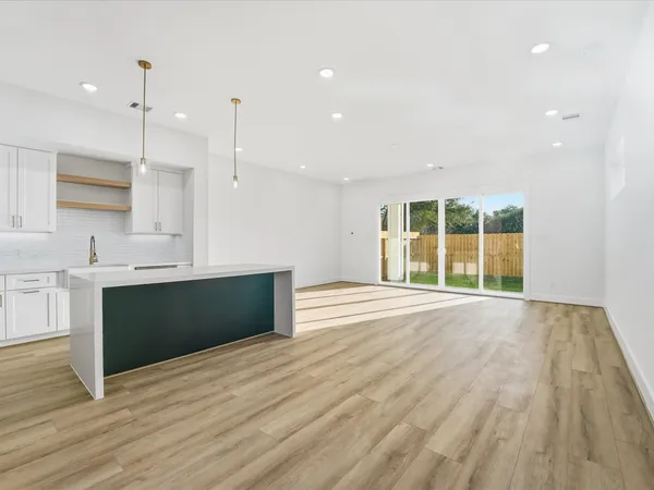 a large kitchen with stainless steel appliances a large counter top