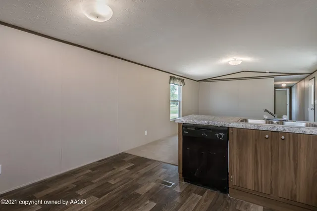 a view of a kitchen with a sink wooden cabinets and wooden floor