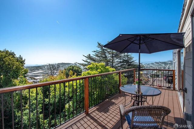 a patio with table and chairs and potted plants