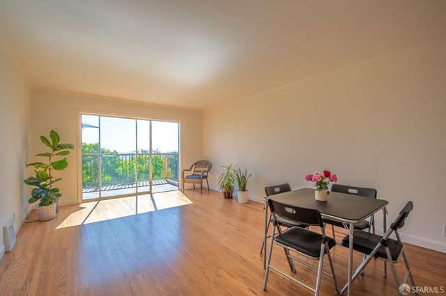 a kitchen with stainless steel appliances granite countertop a sink a stove cabinets wooden floor and a window