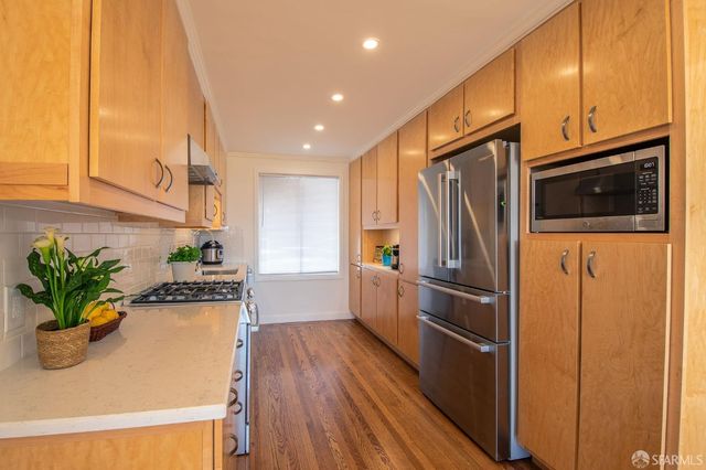 a kitchen that has a lot of cabinets and wooden floor