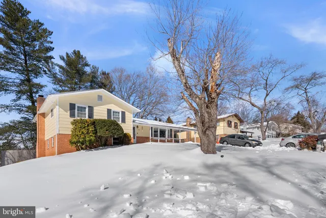 a front view of a house with a yard covered in snow