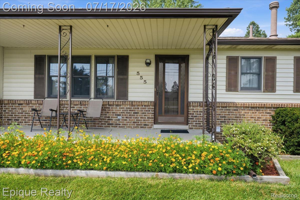 555 East Square Lake Road Troy, MI 48085 - Photo 7 of 48 Inviting front porch featuring a decorative wrought iron support column, brick skirting, and a brown paneled entry door