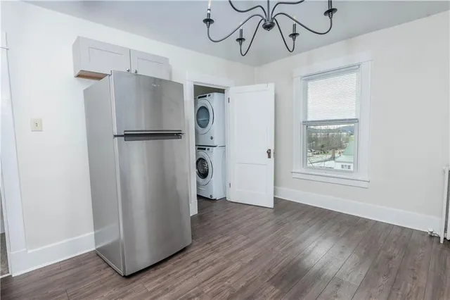 a view of a kitchen with a refrigerator and wooden floor
