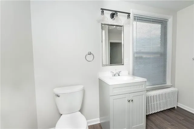 a bathroom with a toilet a sink and mirror