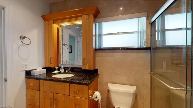 a bathroom with a sink a toilet and a mirror