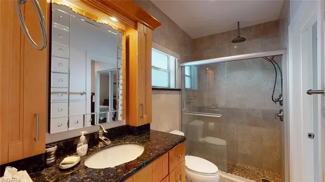 a bathroom with a sink toilet a mirror and shower