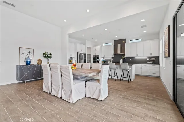 a living room with furniture and a dining table with kitchen view
