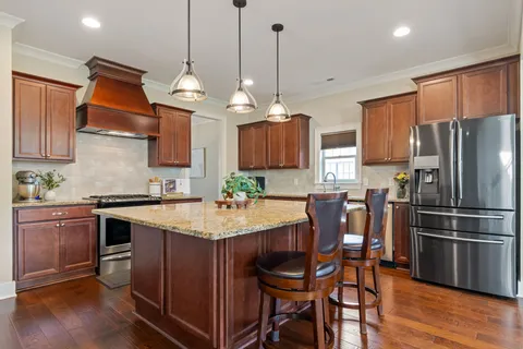 a kitchen with stainless steel appliances wooden floor dining table and chairs