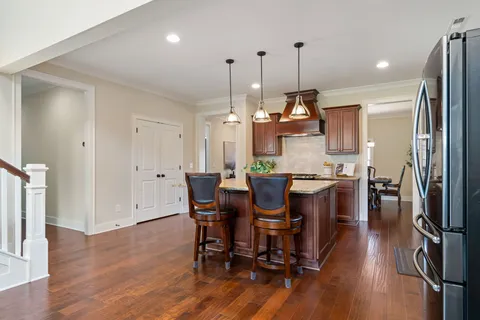 a kitchen with stainless steel appliances granite countertop a sink a stove and a wooden floors