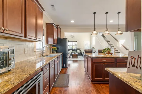 a kitchen with stainless steel appliances granite countertop a refrigerator a sink a stove and island