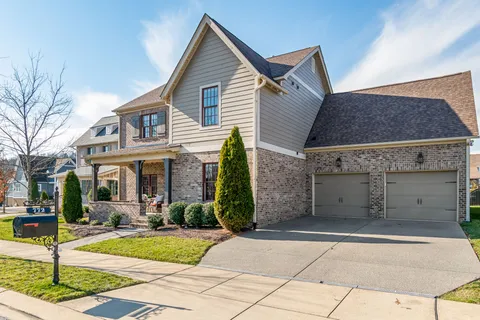 a view of a white house with large windows and plants