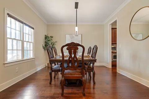 a view of a a dining room with furniture window and wooden floor