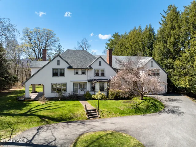 a view of house with garden and tall trees