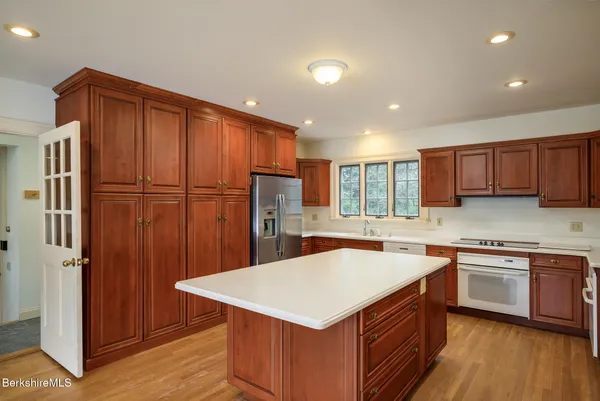 a kitchen with a sink a refrigerator a counter top space and cabinets