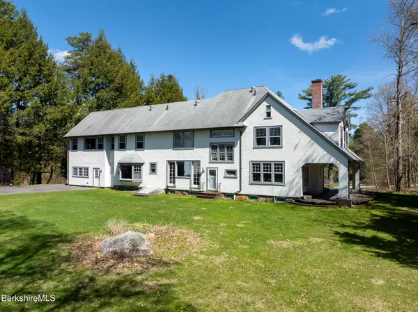 a front view of a house with a yard porch and outdoor seating