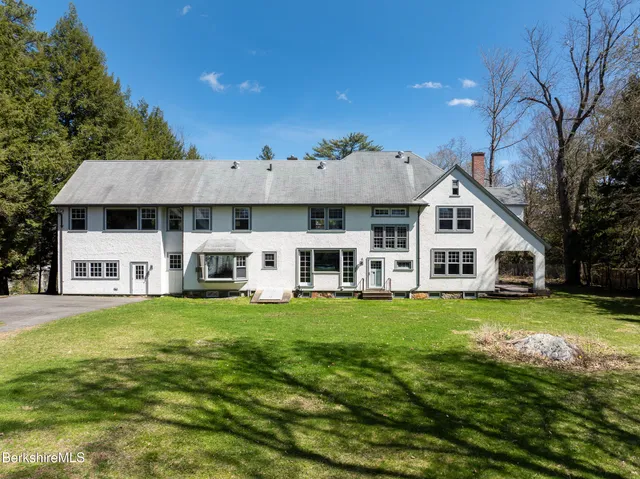 a aerial view of a house next to a big yard and large trees