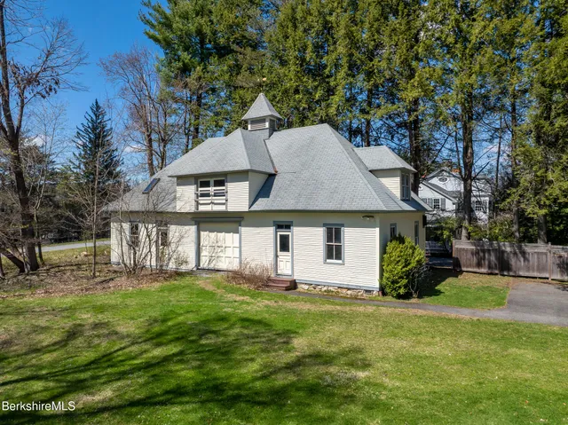 an aerial view of a house with a yard and large tree