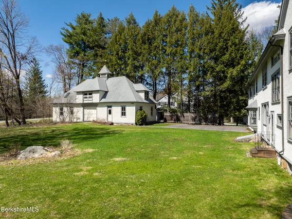 a aerial view of a house next to a big yard and large trees