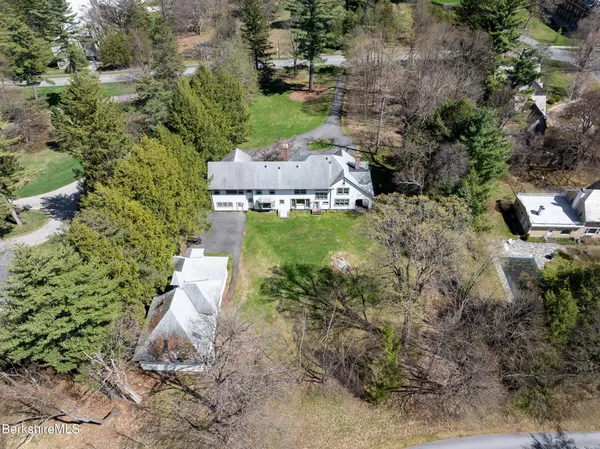 an aerial view of a house with a yard and large tree