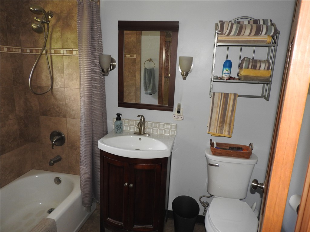 2185 East Loy Road Piqua, OH 45356 - Photo 11 of 19 This functional bathroom features a tiled shower and a modern vanity, providing essential comfort.