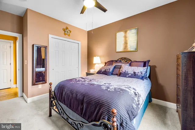 a bedroom with a bed and a chair with the bookshelf