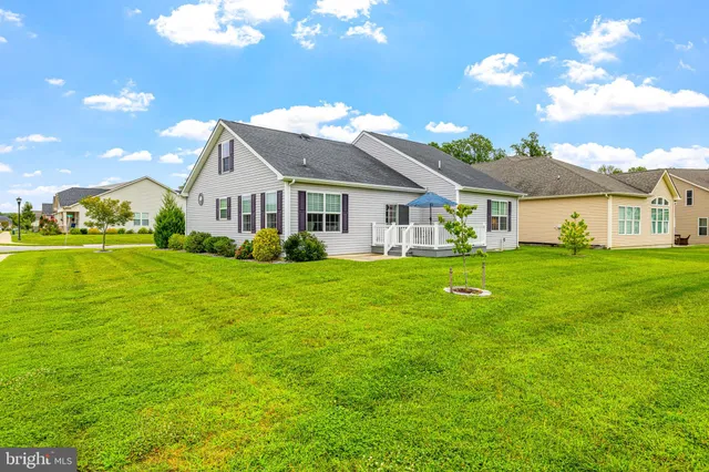 a patio with wooden floor a yard a table and chairs