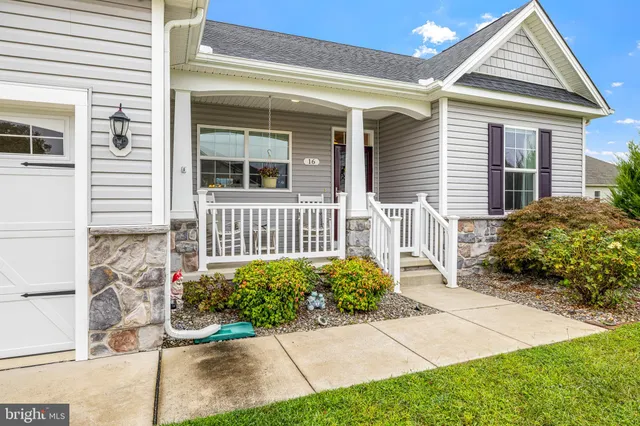 a front view of a house with a yard and large trees