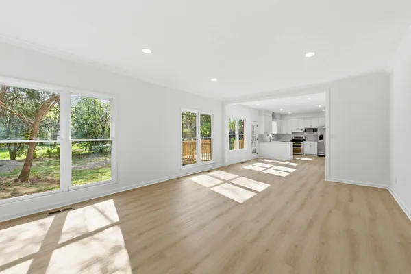 a view of empty room with wooden floor and windows