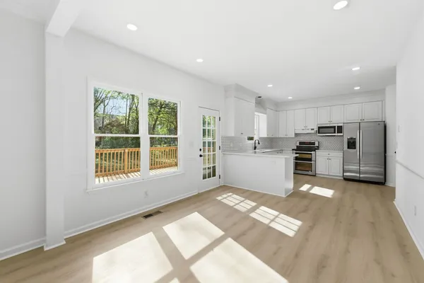 a view of a kitchen with a sink wooden cabinets and windows