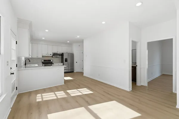 a kitchen with stainless steel appliances kitchen island granite countertop a refrigerator and a sink