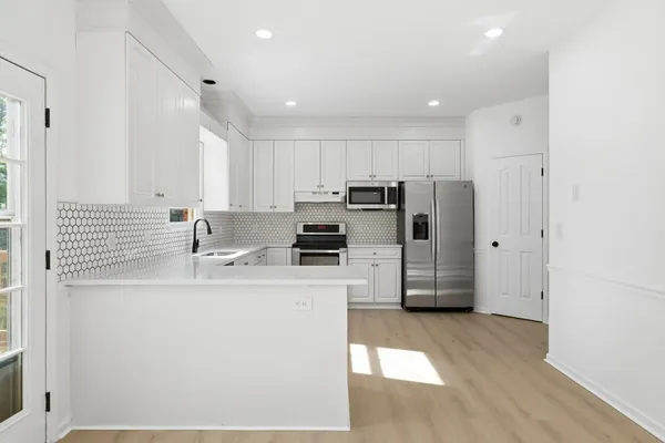 a kitchen with kitchen island a sink stainless steel appliances and cabinets