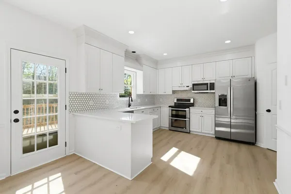 a kitchen with stainless steel appliances a refrigerator and a stove top oven