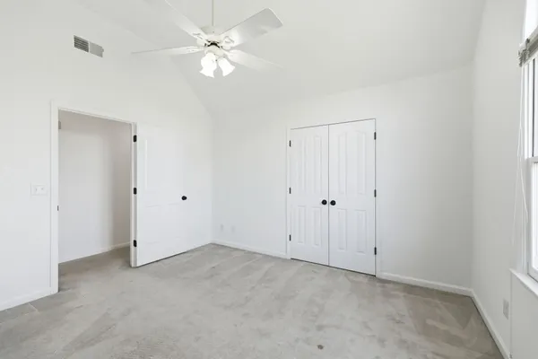 a view of an empty room with a ceiling fan