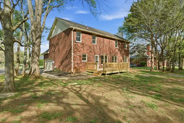 a view of a house with backyard and trees