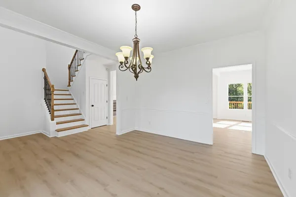 a view of a hallway with wooden floor and staircase