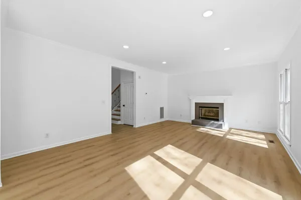 a view of empty room with wooden floor and fireplace