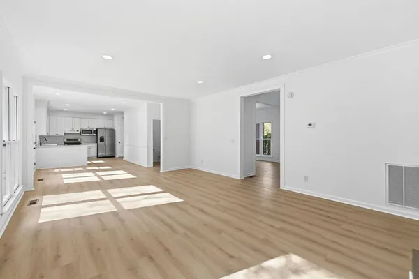 a view of a living room and kitchen with wooden floor