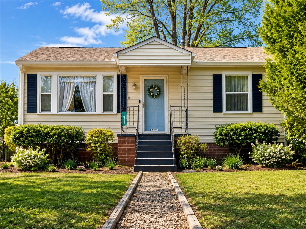Charming bungalow with manicured landscaping and inviting front porch.