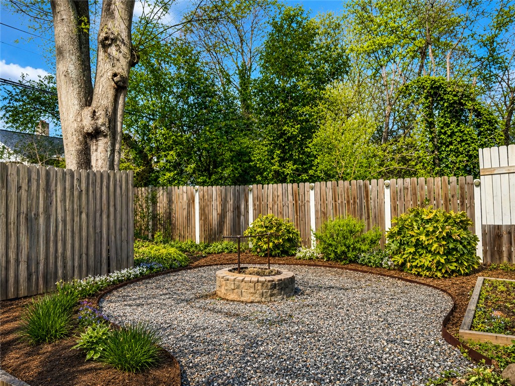 1909 Northview Avenue Anderson, SC 29625 - Photo 17 of 21 This yard features a charming fire pit, perfect for outdoor gatherings, surrounded by a privacy fence and lush landscaping.